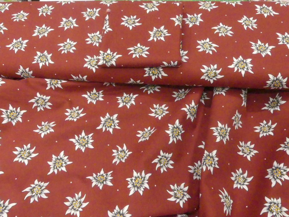 Tissu edelweiss fond bordeaux